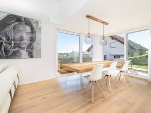 Der massive Holztisch und die Sitzbank wirken mit den Beinen aus Glas fast schwebend.