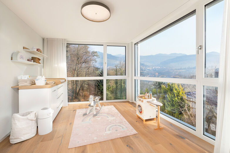 Das Eckfenster bietet einen atemberaubenden Blick in ­ die Umgebung und in die Baumkronen des nahen Waldes.