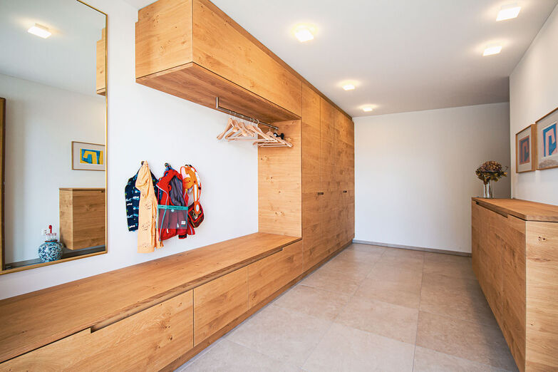 Viel Stauraum bietet die nach Mass gefertigte Garderobe.