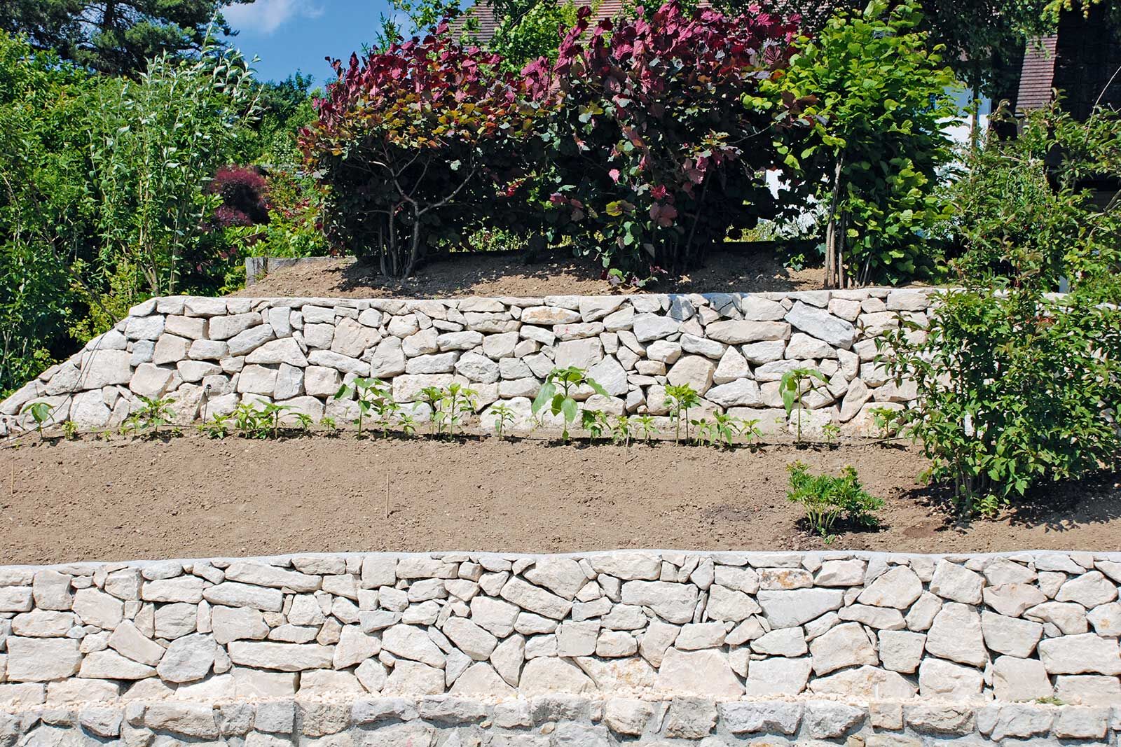 Mit Natursteinen lassen sich Hänge im Garten gut absichern.