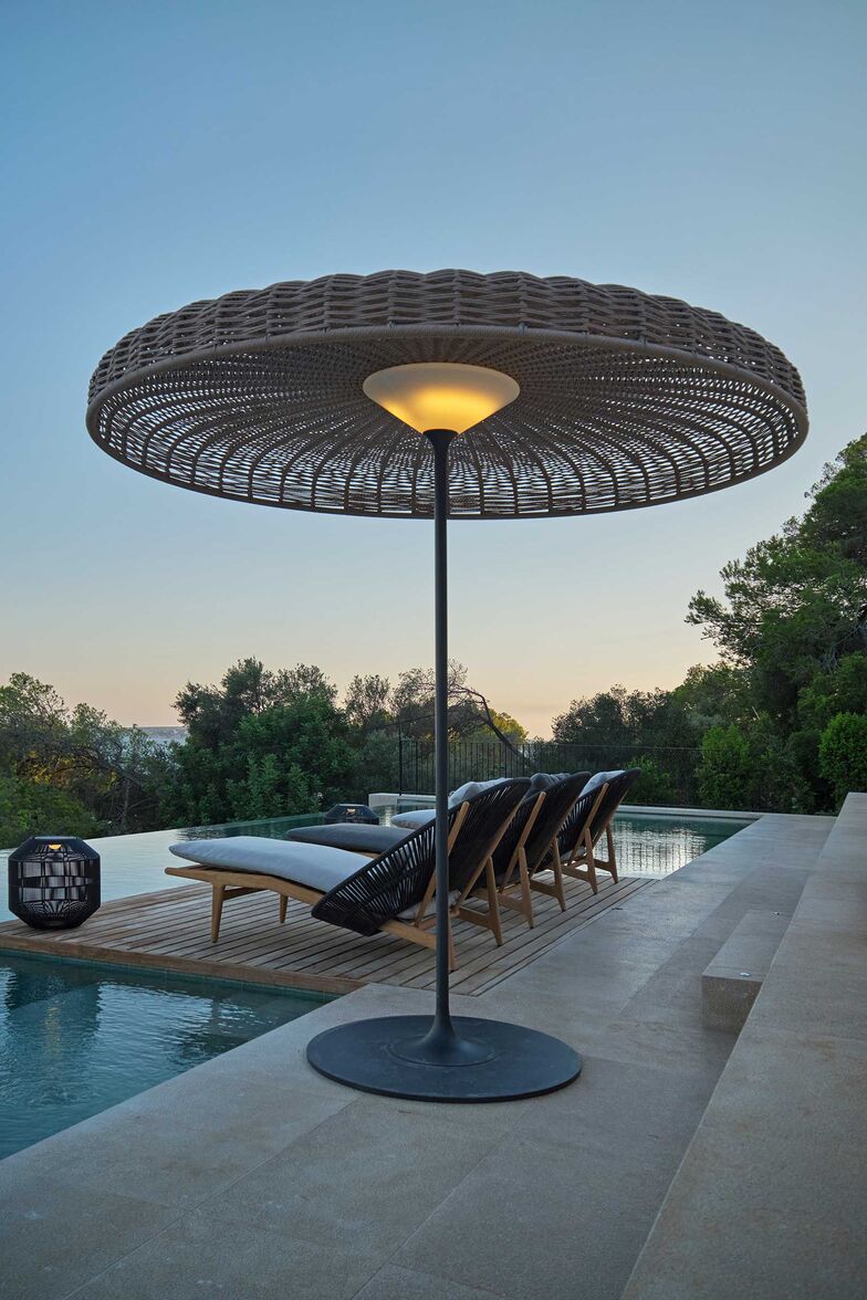 Die freistehende Leuchte «Ambient Sol» spendet am Tag Schatten, am Abend entsteht darunter eine gleichmässige Beleuchtung. Sie besteht aus einem Aluminiumrahmen mit geflochtenem Dach. www.gloster.com