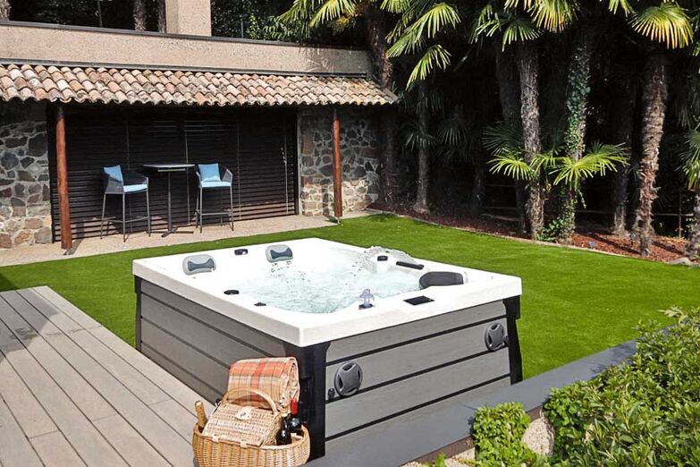 Rückzugsort im Grünen: Ein hochwertiger Whirlpool fügt sich ­harmonisch in die Gartengestaltung ein und wird zum Mittelpunkt für entspannte Abende.