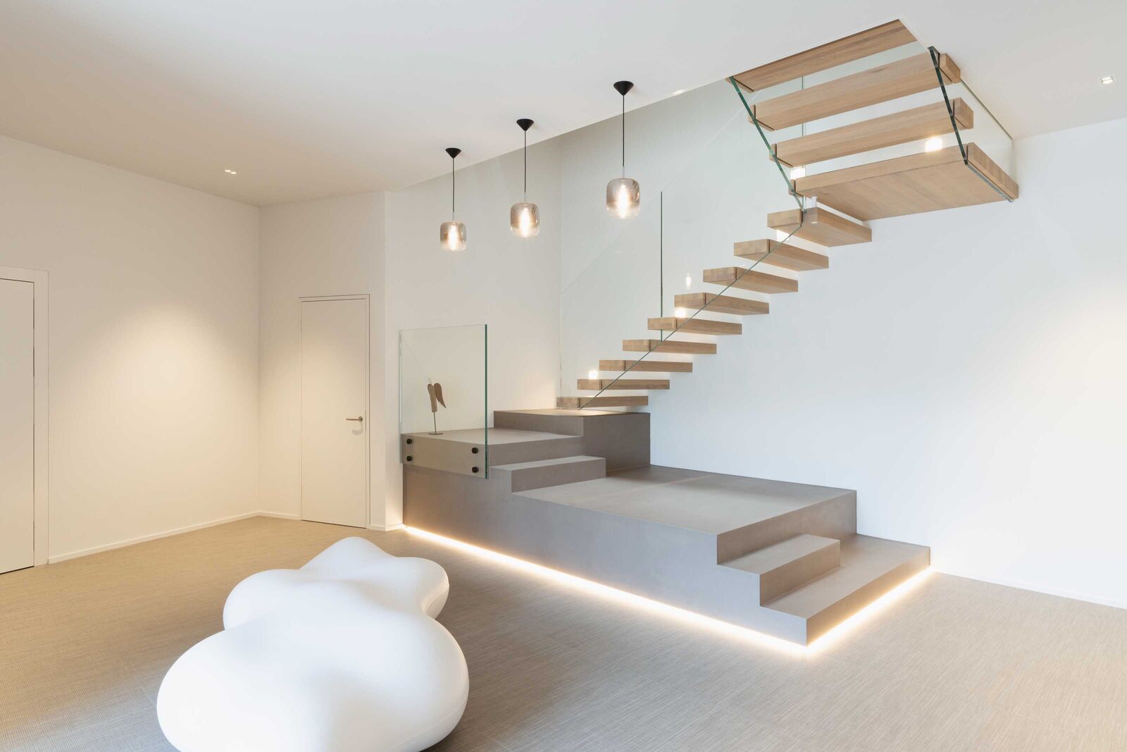 Die freitragenden Eichenstufen mit Glasgeländern und viel Licht lassen diese Treppe leicht und grosszügig wirken. Columbus Treppen AG, www.columbus.ch
