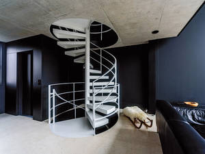 Die Geländer aus Flachstahl dieser dreiläufigen Spindeltreppe im Haus eines Architekten wurden vor Ort geschweisst. Columbus Treppen AG.