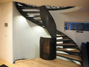 Diese Podesttreppe mit abgetreppten Wangen aus Stahl, Stufen aus Stahlwangen und einem dunklen Eichenparkett lässt einen richtig schwungvoll in die obere Etage laufen. Langegg Treppenbau.