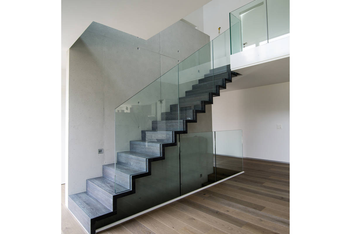 Schlicht und dennoch wirkungsvoll: Faltwerktreppe in gebeizter Eiche, deren Glasbrüstung lichtseitig ins Massivholz eingenutet wurde. Keller Treppenbau AG.