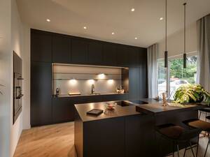 Die Küche «Orea X» besticht durch ihre dunkle Farbe. Die helle Rückwand sorgt für den gelungenen Kontrast. Foto: Andre Herger Fotografie GmbH. Orea AG.