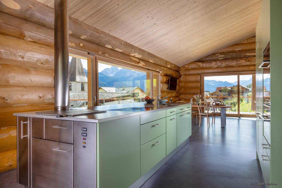 Nicht nur in Alphütten beliebt: Der Zentralheizungsherd in dieser Stahlküche dient gleichzeitig zum Kochen und zum Heizen. Tiba AG.